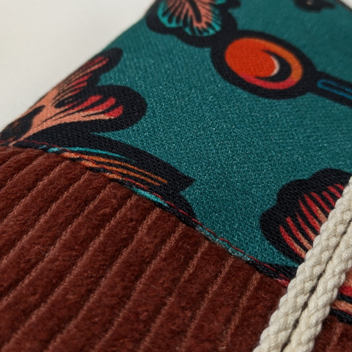Zoom sur les finitions d'une pochette à livre broché velours côtelé brique et coton imprimé