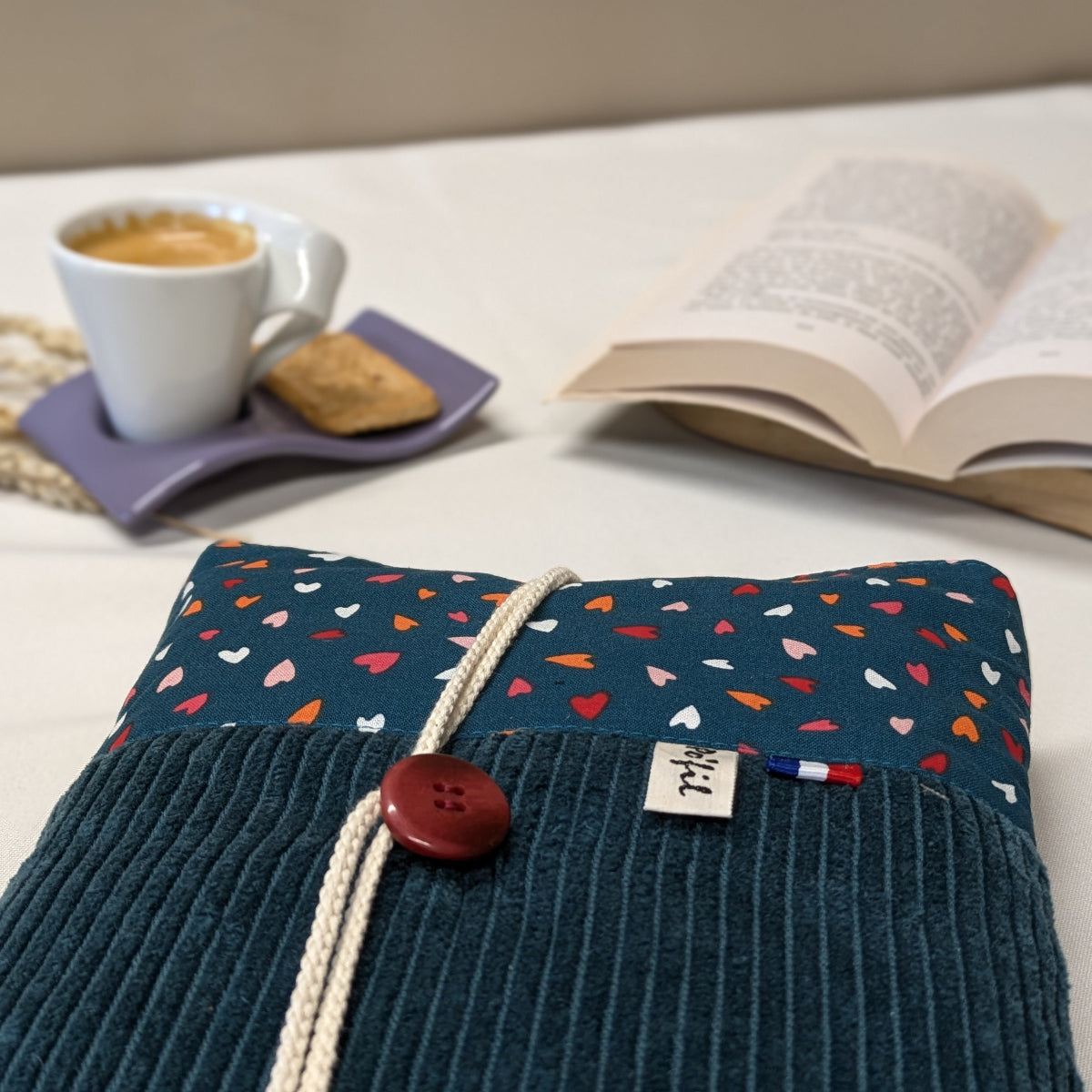 Zoom sur les finitions d'une pochette à livre broché velours côtelé bleu vert et coton imprimé