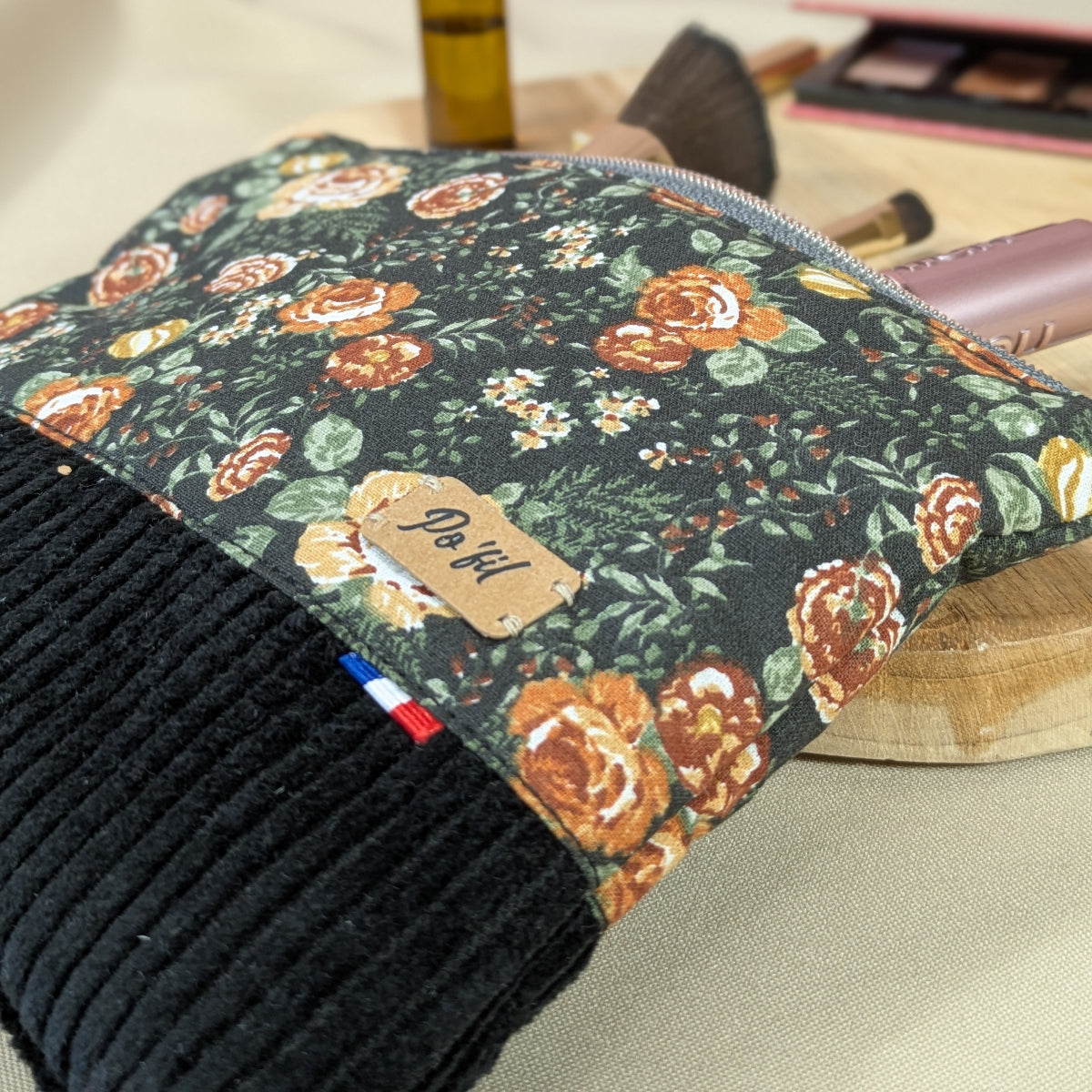 Sa taille est idéale pour être glissée dans un sac. Zoom sur les détails fleuris sur fond noir du coton imprimé
